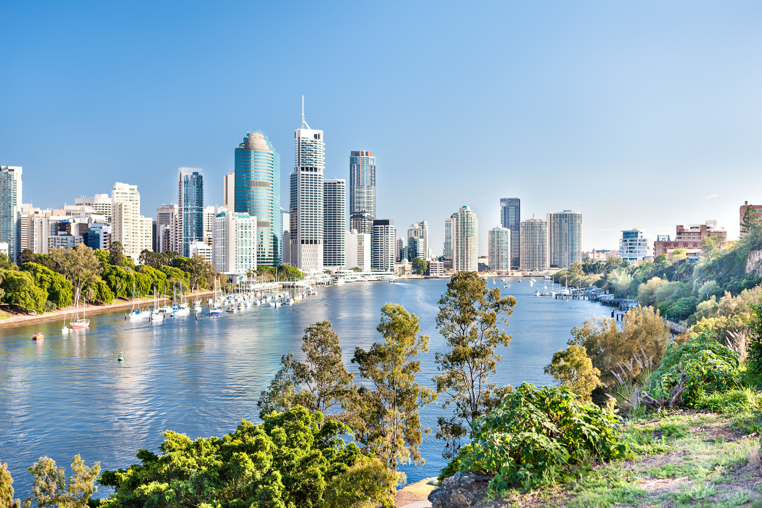 Blue water river surrounded by trees beside a modern city